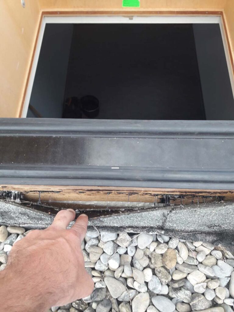 Hand zeigt auf Dachöffnung mit Kieseln.