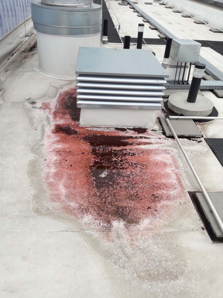 Rotes Leck auf Flachdach nahe Lüftungsanlage
