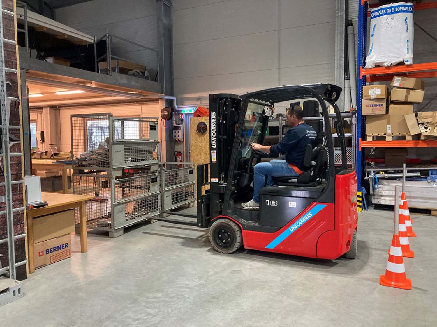 Mann fährt Gabelstapler in Lagerhalle