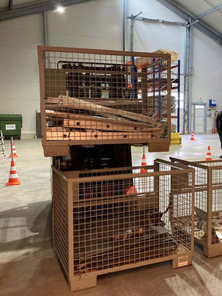 Gabelstapler hebt Metallkisten in Lagerhalle